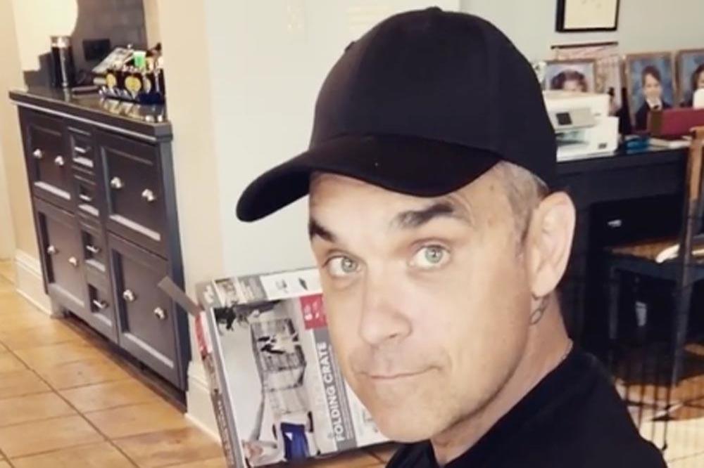 Robbie Williams cradles newborn son Beau (c) Instagram 