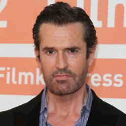 Rupert Everett tries to avoid his reflection as he ages