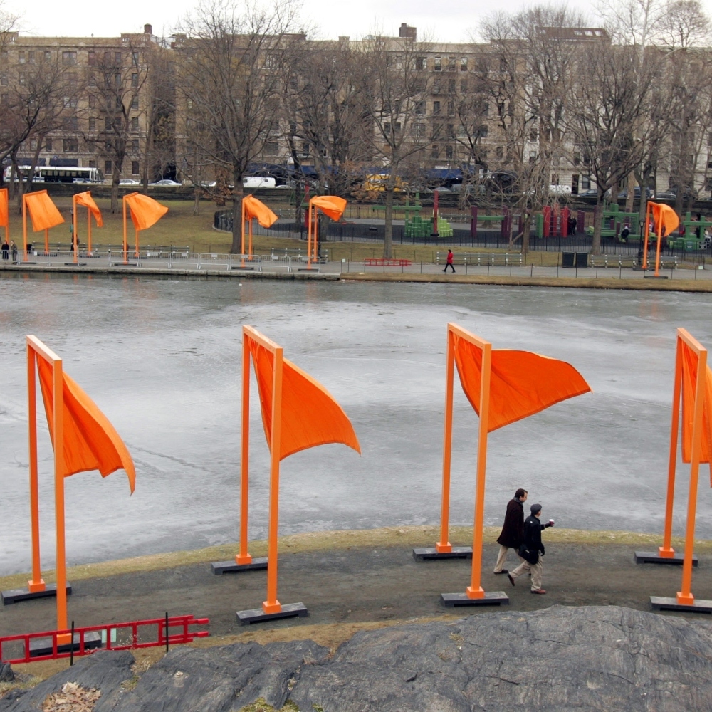 Pedestrians walk along the edge of Harlem Meer under The Gates project by artists Christo and Jeanne-Claude in New York's Central Park