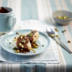 Poached pears with chocolate sauce and pistachios